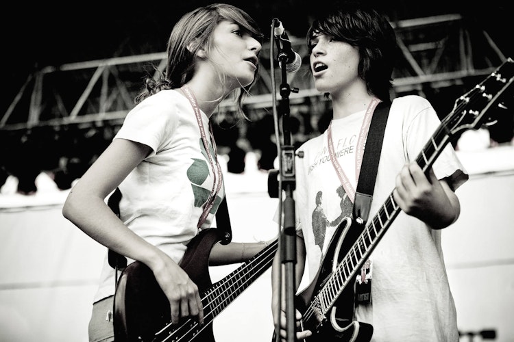 School of Rock students singing at a microphone using vocal health tips for singers.