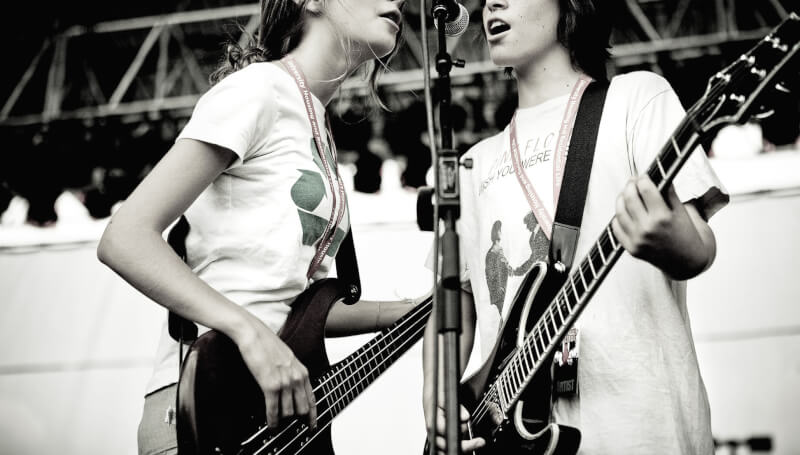 School of Rock students singing at a microphone using vocal health tips for singers.