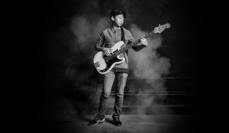 Student learning to play bass guitar