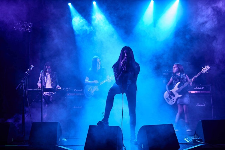 Teens playing music in School of Rock's performance program
